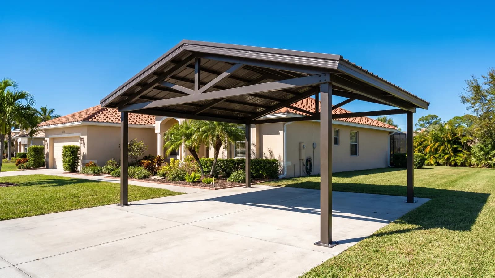 A metal carport with a gabled roof covering a driveway beside a single-family Florida home under bright daylight.