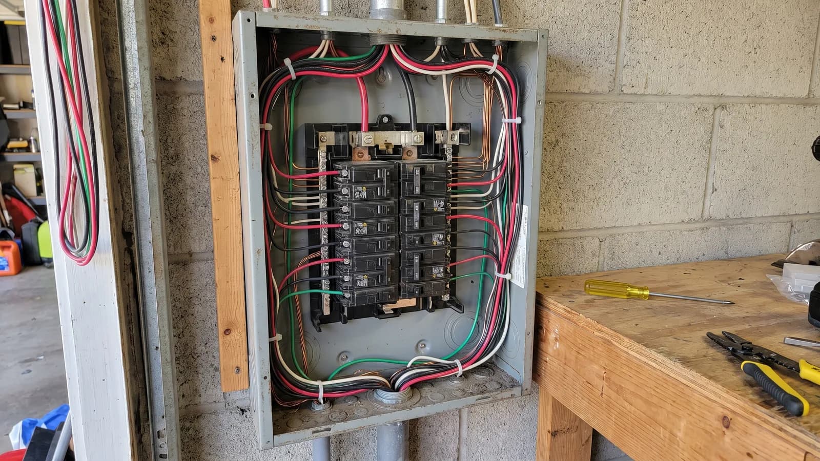 An open residential electrical service panel showing breakers and neatly routed circuit wiring