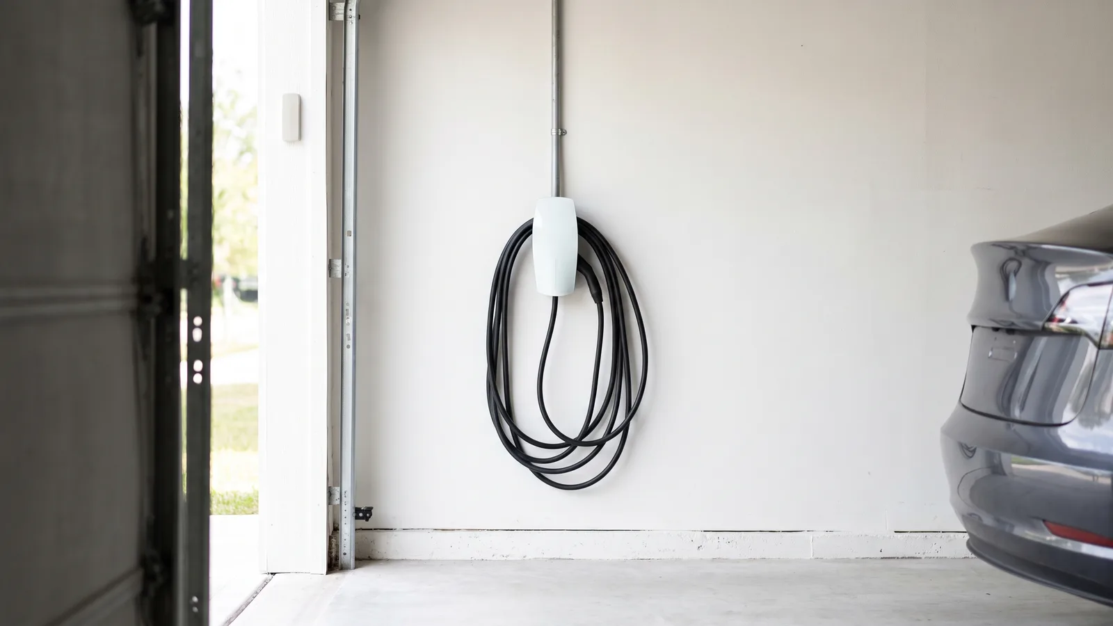 A Level 2 electric vehicle charger mounted on a home garage wall