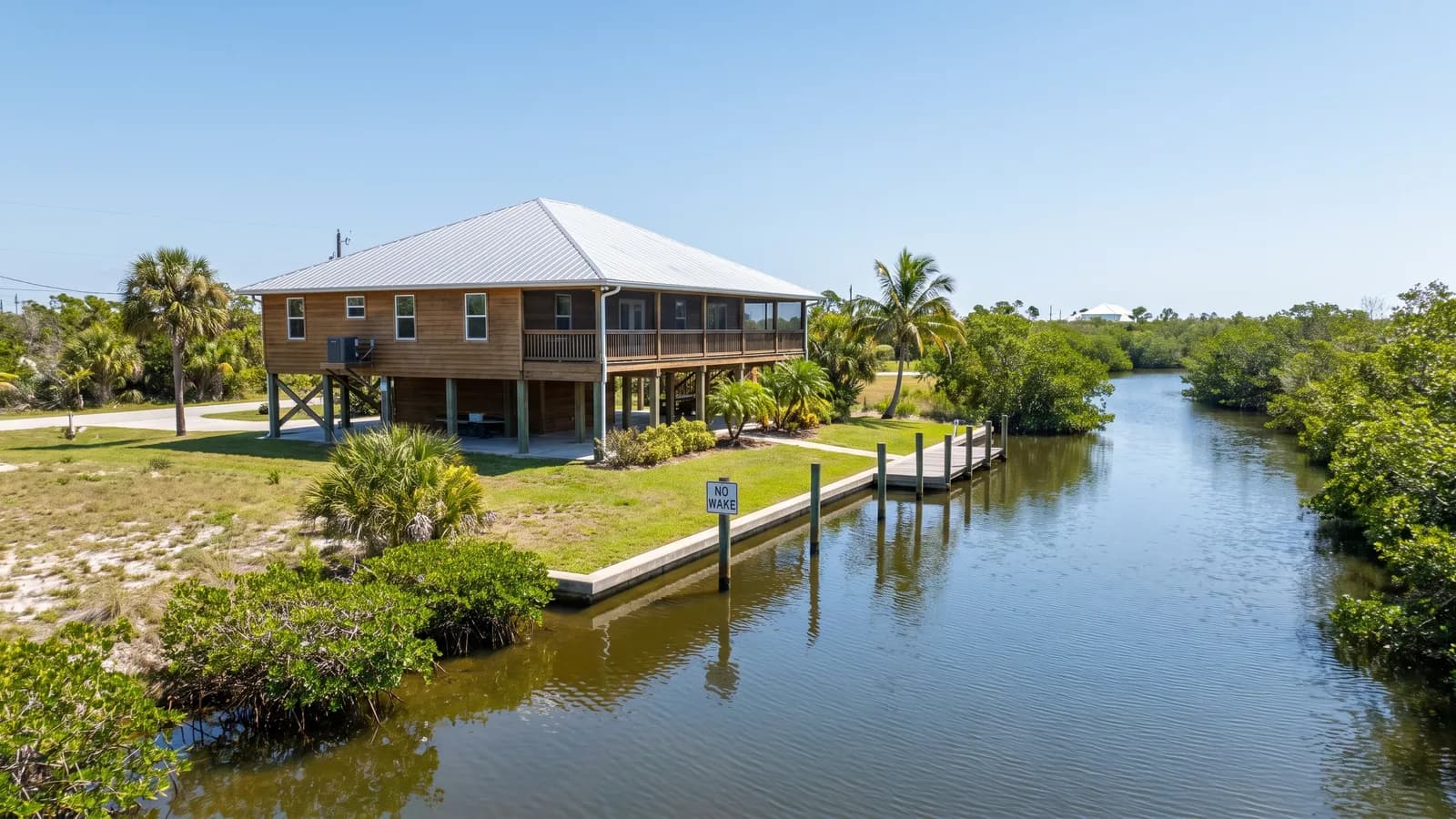 A Florida home near water on a bright day, suggesting a coastal or low-lying flood-prone setting.
