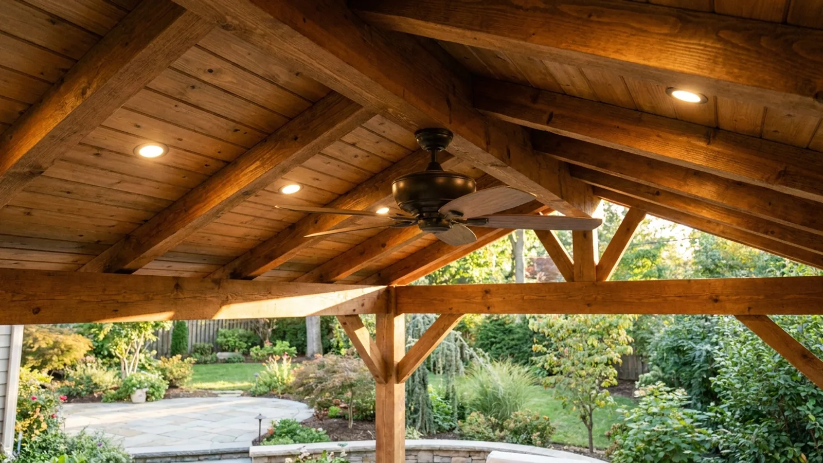 A wired ceiling fan and hardtop inside a permanent backyard gazebo