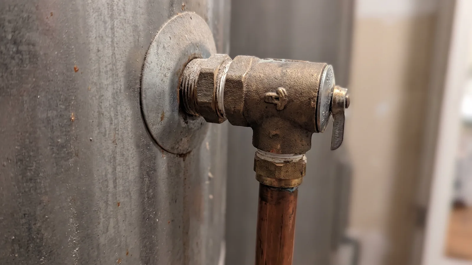 A plumber connecting supply lines and a temperature and pressure relief valve on a water heater